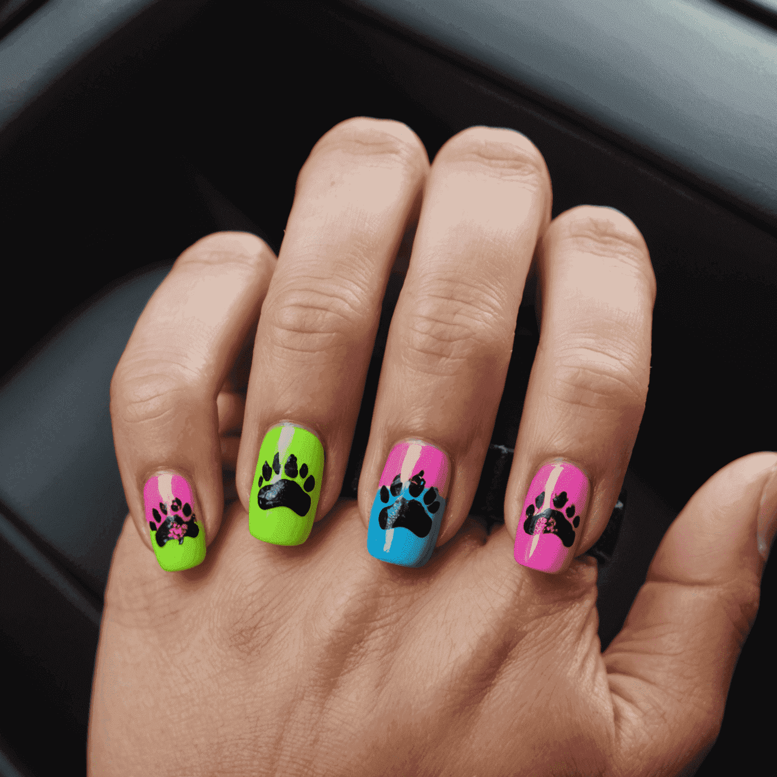 A close-up of a dog's paw with neon-colored nail polish and tiny punk rock decals